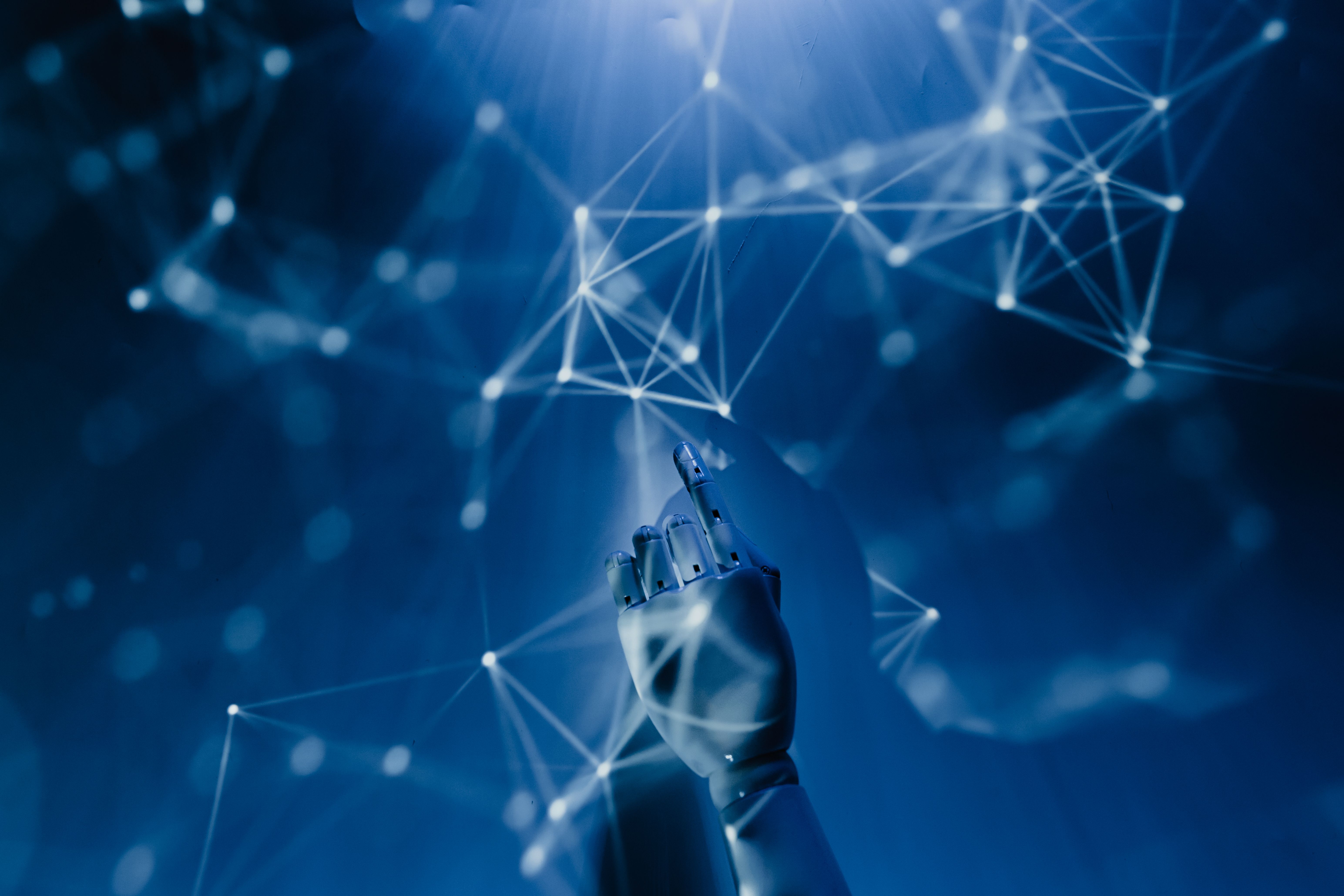 Graphic of a robotic hand touching a net of virtual connections