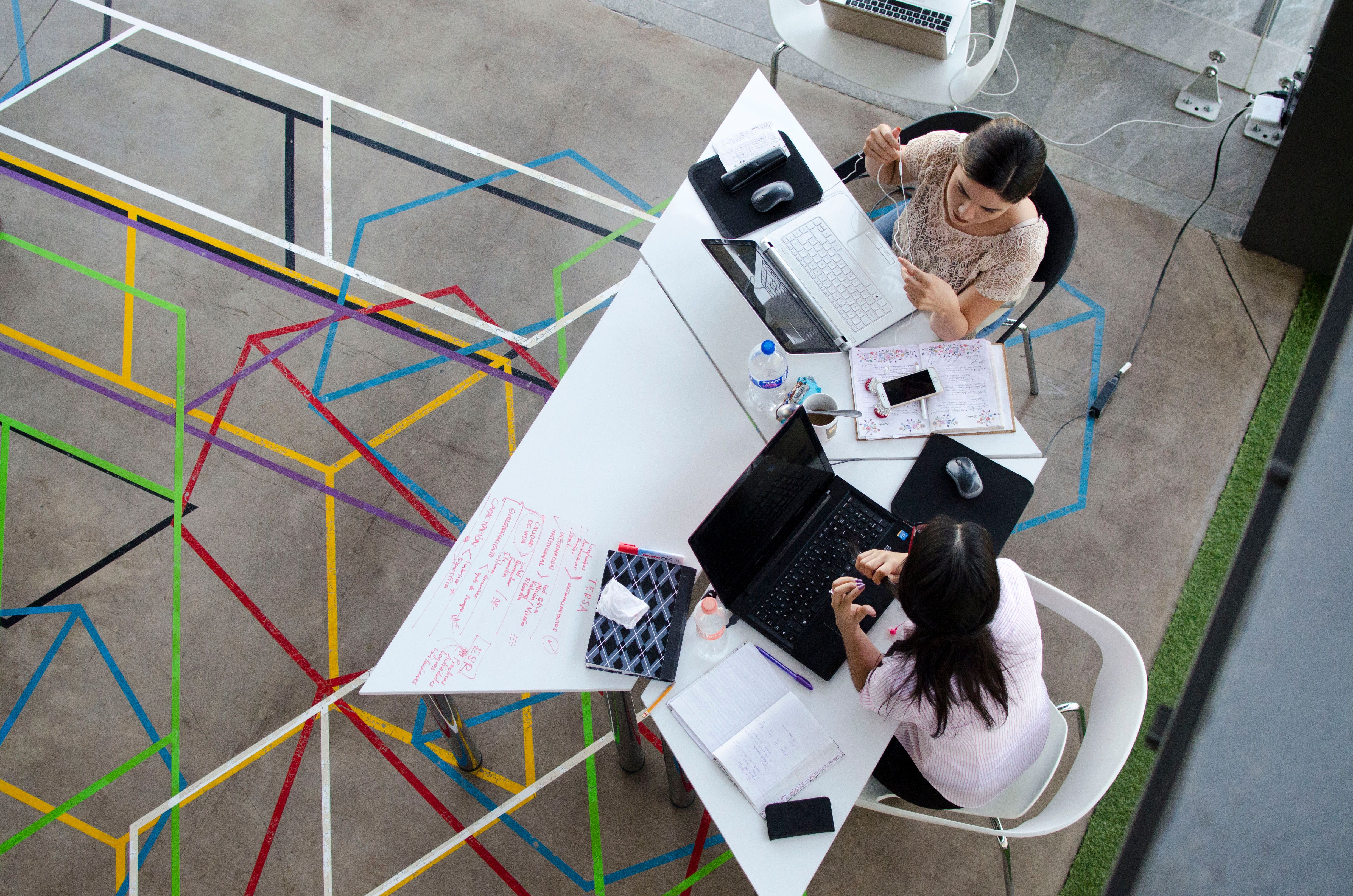 Bird's eye photo of two women sitting at a desk